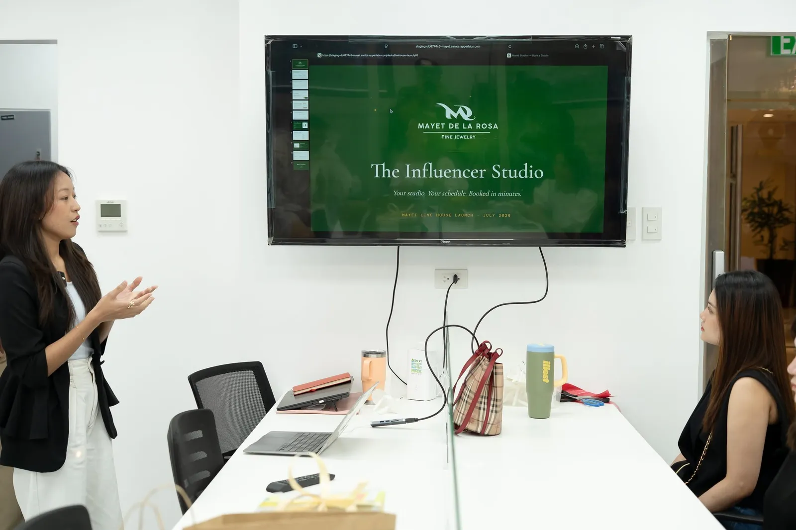 A presenter beside a wall screen showing The Influencer Studio, the Mayet Live House launch deck